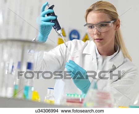 Picture - Researcher pipetting liquid. Fotosearch