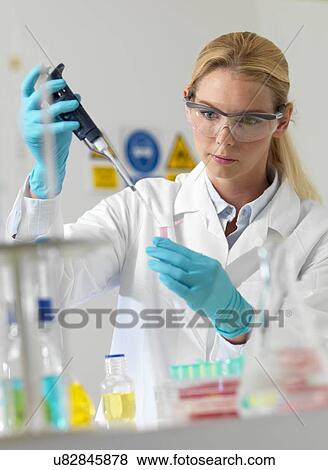 Stock Photo - Researcher pipetting liquid. Fotosearch