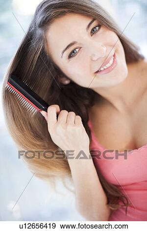 Stock Photo - Woman brushing her hair. Fotosearch