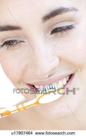 Picture - Woman brushing her teeth. Fotosearch