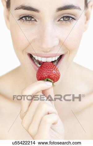 Picture - Woman eating a strawberry. Fotosearch