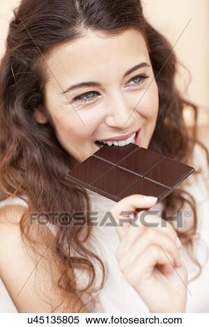 Stock Photography - Woman eating chocolate. Fotosearch