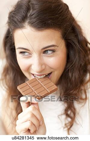 Stock Photography - Woman eating chocolate. Fotosearch