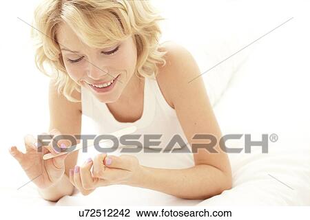 Woman filing her nails View Large Photo Image Stock Image - Woman filing her nails. Fotosearch
