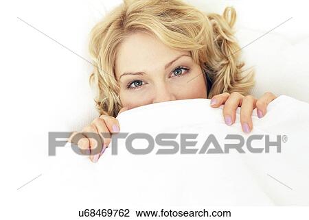 Woman hiding under the covers View Large Photo Image Stock Image - Woman hiding under the covers. Fotosearch