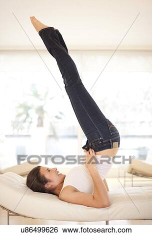 Stock Photograph - Woman putting on jeans. Fotosearch