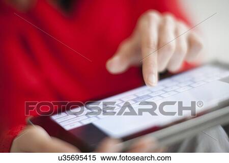 Woman using a tablet computer View Large Photo Image Stock Photography - Woman using a tablet computer. Fotosearch