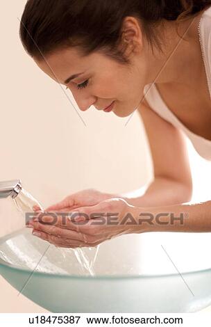 Woman washing her face View Large Photo Image Stock Photo - Woman washing her face. Fotosearch