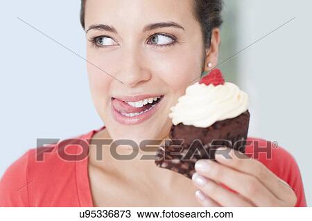 Stock Image - Woman with a cup cake. Fotosearch
