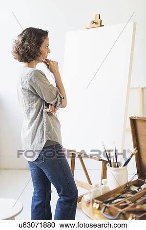 Stock Image - Artist standing in front of canvas. Fotosearch
