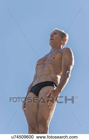 Stock Image - Athletic swimmer against blue sky. Fotosearch