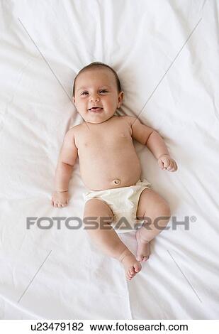 Baby girl (2-5 months) lying on bed View Large Photo Image Stock Image - Baby girl (2-5 months) lying on bed. Fotosearch