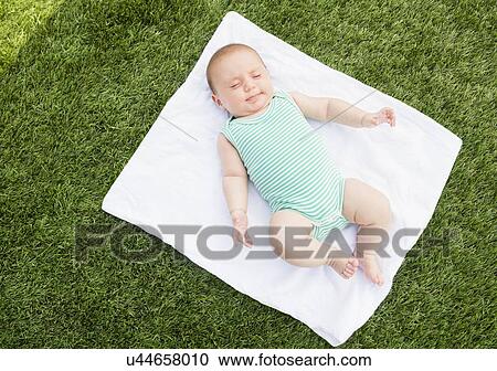 Baby girl (2-5 months) lying on blanket on grass View Large Photo Image Stock Image - Baby girl (2-5 months) lying on blanket on grass. Fotosearch