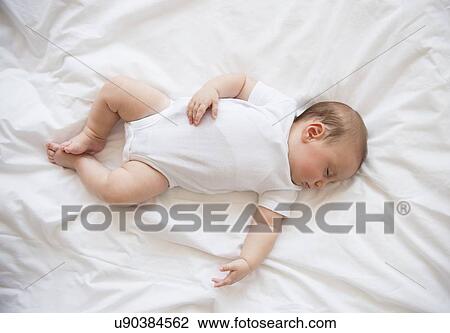 Stock Image - Baby girl (2-5 months) sleeping in bed. Fotosearch