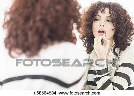Beautiful brunette woman applying lipstick View Large Photo Image Picture - Beautiful brunette woman applying lipstick. Fotosearch