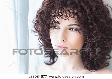 Beautiful woman looking through window View Large Photo Image Stock Photo - Beautiful woman looking through window. Fotosearch