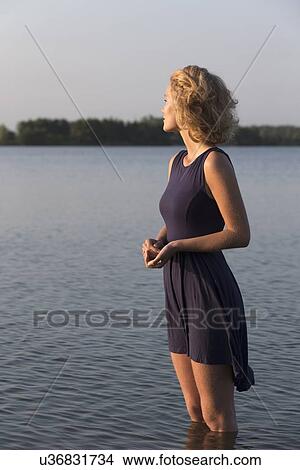 Picture - Beautiful woman standing in lake. Fotosearch