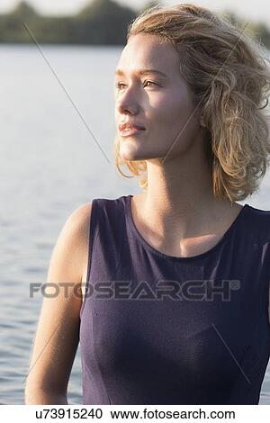 Stock Image - Beautiful woman standing in lake. Fotosearch