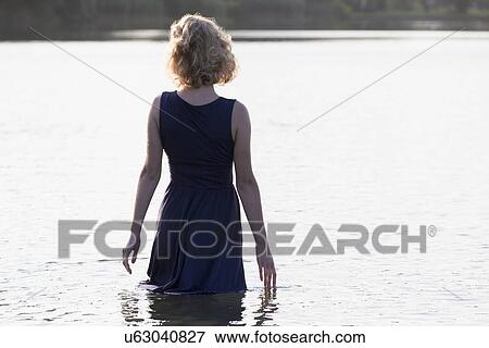 Stock Photo - Beautiful woman standing in lake. Fotosearch