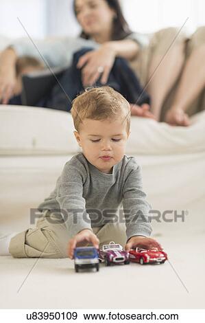 Boy (12-17 months) playing on floor View Large Photo Image Stock Photo - Boy (12-17 months) playing on floor. Fotosearch