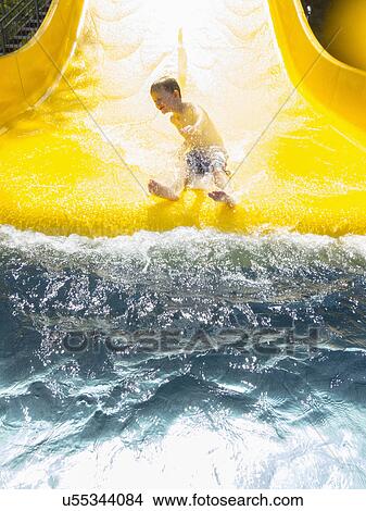 Boy (6-7) having fun on water slide View Large Photo Image Picture - Boy (6-7) having fun on water slide. Fotosearch