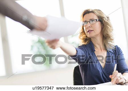 Stock Photo - Business people exchanging documents. Fotosearch