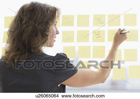 Picture - Business woman arranging yellow notes. Fotosearch