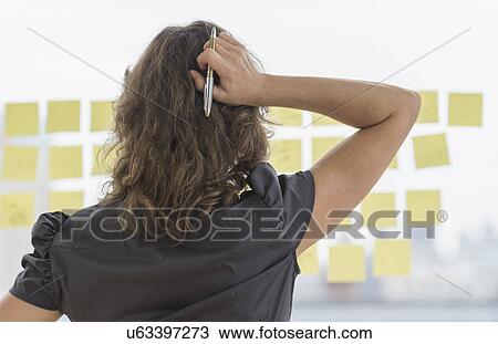 Stock Image - Business woman arranging yellow notes. Fotosearch