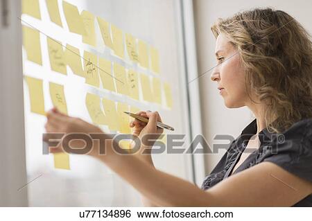 Business woman arranging yellow notes View Large Photo Image Stock Photograph - Business woman arranging yellow notes. Fotosearch