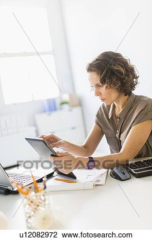 Business woman using digital tablet and laptop View Large Photo Image Stock Image - Business woman using digital tablet and laptop. Fotosearch
