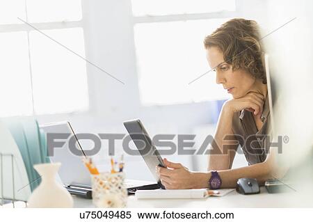 Stock Photography - Business woman using digital tablet and laptop. Fotosearch
