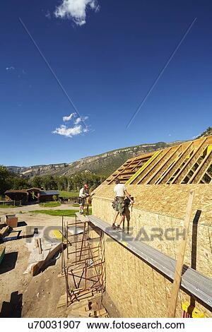 Stock Photo - Construction workers working on construction site. Fotosearch