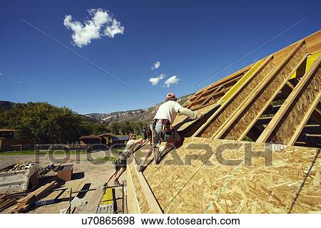 Stock Photo - Construction workers working on construction site. Fotosearch