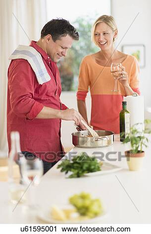 Stock Image - Couple cooking at home. Fotosearch