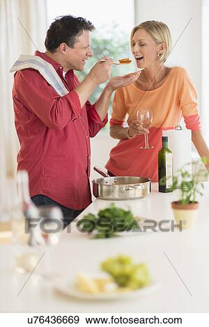 Stock Photo - Couple cooking at home. Fotosearch