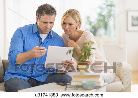 Couple doing paperwork at home View Large Photo Image Stock Image - Couple doing paperwork at home. Fotosearch