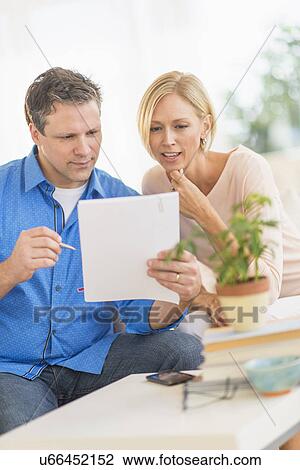 Stock Image - Couple doing paperwork at home. Fotosearch