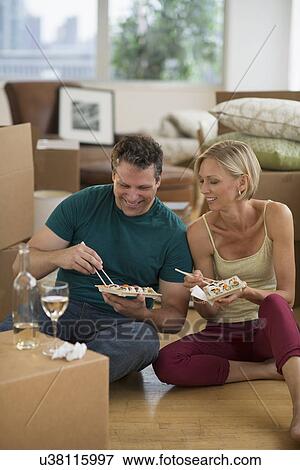 Couple eating sushi in new home View Large Photo Image Stock Photo - Couple eating sushi in new home. Fotosearch