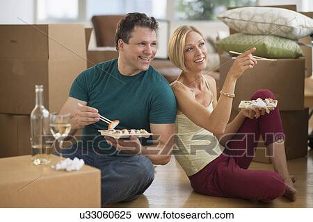 Couple eating sushi in new home View Large Photo Image Stock Photography - Couple eating sushi in new home. Fotosearch