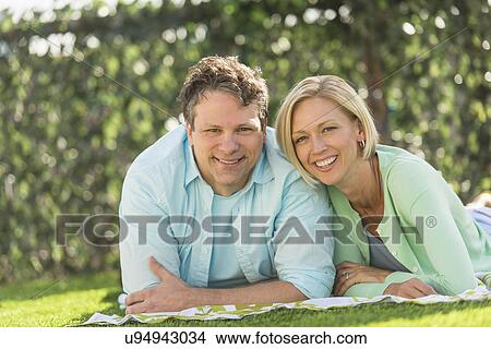 Couple lying on grass View Large Photo Image Picture - Couple lying on grass. Fotosearch