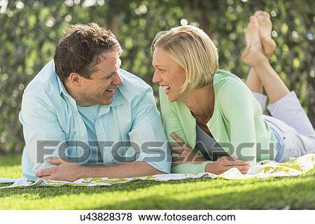 Couple lying on grass View Large Photo Image Stock Photo - Couple lying on grass. Fotosearch