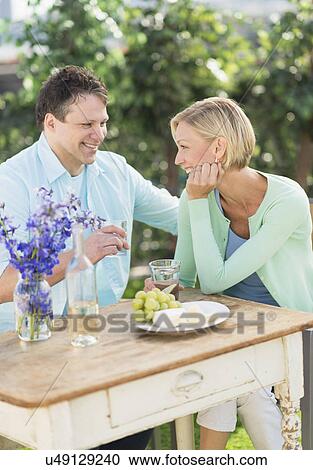 Couple sitting at table outdoors View Large Photo Image Stock Image - Couple sitting at table outdoors. Fotosearch