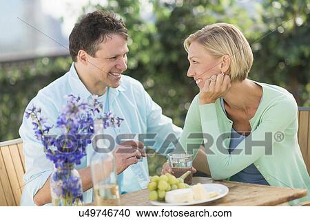 Couple sitting at table outdoors View Large Photo Image Stock Image - Couple sitting at table outdoors. Fotosearch