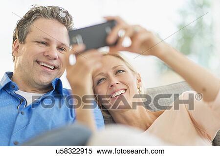Couple taking self-portrait photo with smartphone View Large Photo Image Stock Photography - Couple taking self-portrait photo with smartphone. Fotosearch