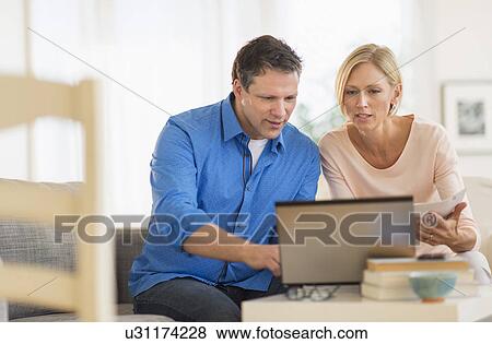 Stock Photo - Couple using laptop at home. Fotosearch