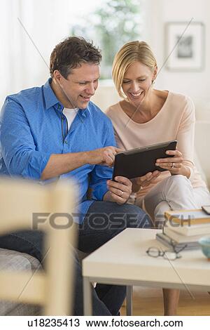 Stock Image - Couple using tablet pc at home. Fotosearch