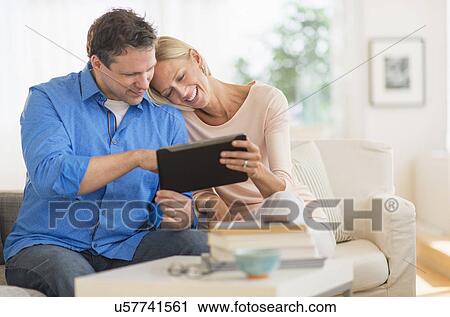 Stock Image - Couple using tablet pc at home. Fotosearch