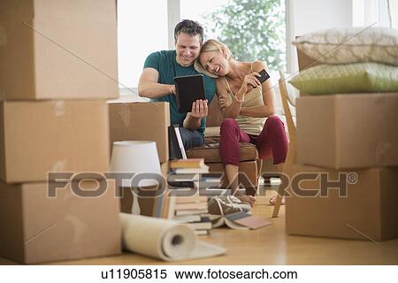 Couple using tablet pc in new home View Large Photo Image Stock Photography - Couple using tablet pc in new home. Fotosearch