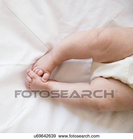 Feet of baby girl (2-5 months) lying on bed View Large Photo Image Stock Photo - Feet of baby girl (2-5 months) lying on bed. Fotosearch