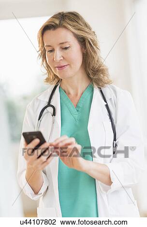 Female doctor using phone View Large Photo Image Stock Image - Female doctor using phone. Fotosearch
